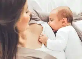 baby breastfeeding from a smiling woman