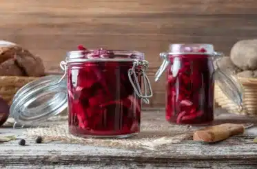 Two open jars of beet kvass on a counter