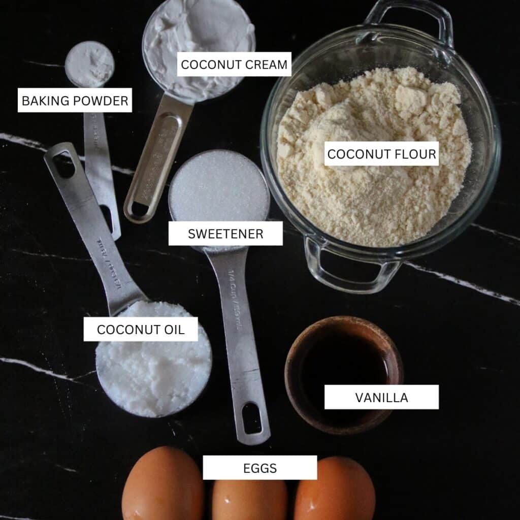 Ingredients for making keto blondies, including coconut flour, coconut oil, eggs, coconut cream, vanilla, baking powder and keto sweetener.