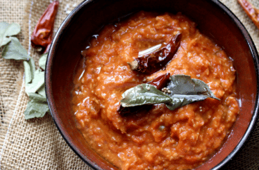 coconut tomato chutney in a bowl with garnish on top.