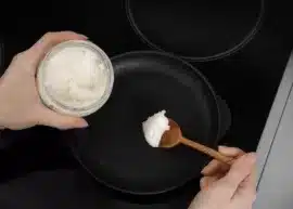 Woman cooking with coconut oil (pan, wooden spoon, and coconut oil).