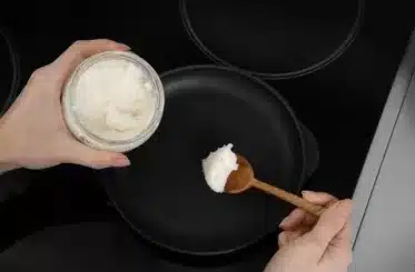 Woman cooking with coconut oil (pan, wooden spoon, and coconut oil).
