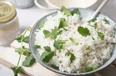 Coconut rice in a bowl with chopped greens on top