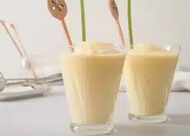 Two homemade dole whips in cups with fancy straws stuck in them