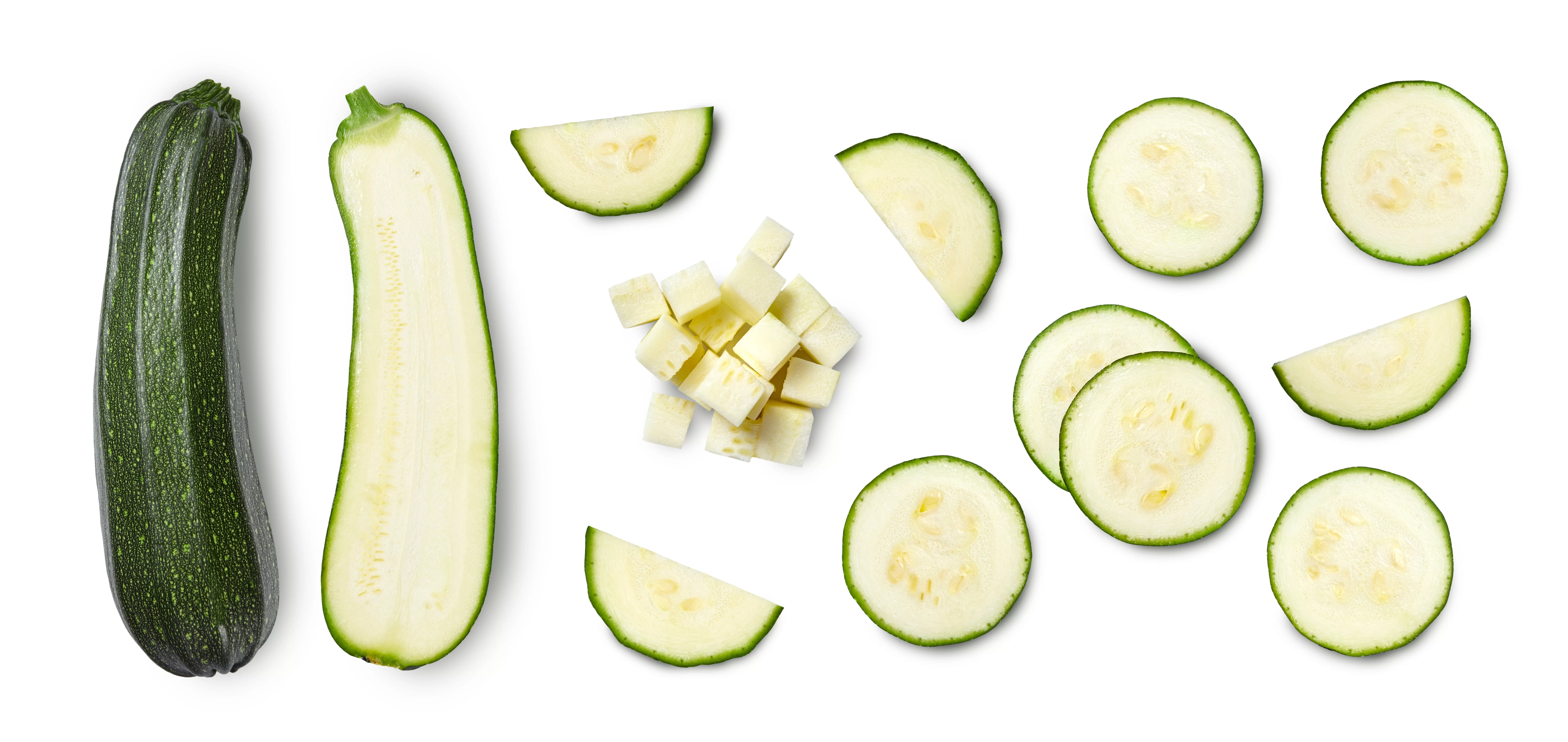 A whole zucchini and then various slices of zucchini.