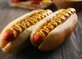 two hot dogs with mustard on top