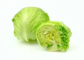 Whole iceberg lettuce next to a halved one on a white background.