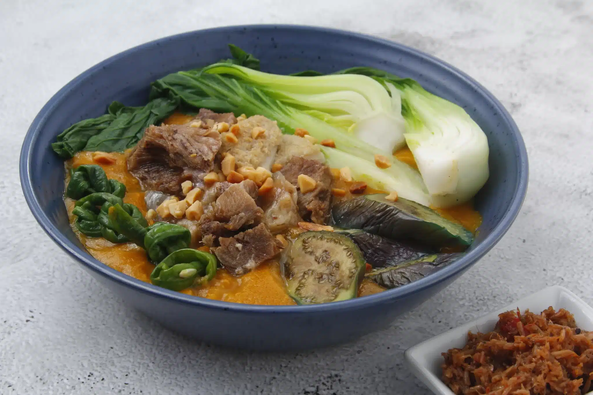 A freshly prepared serving of kare-kare on a platter, ready to be enjoyed.