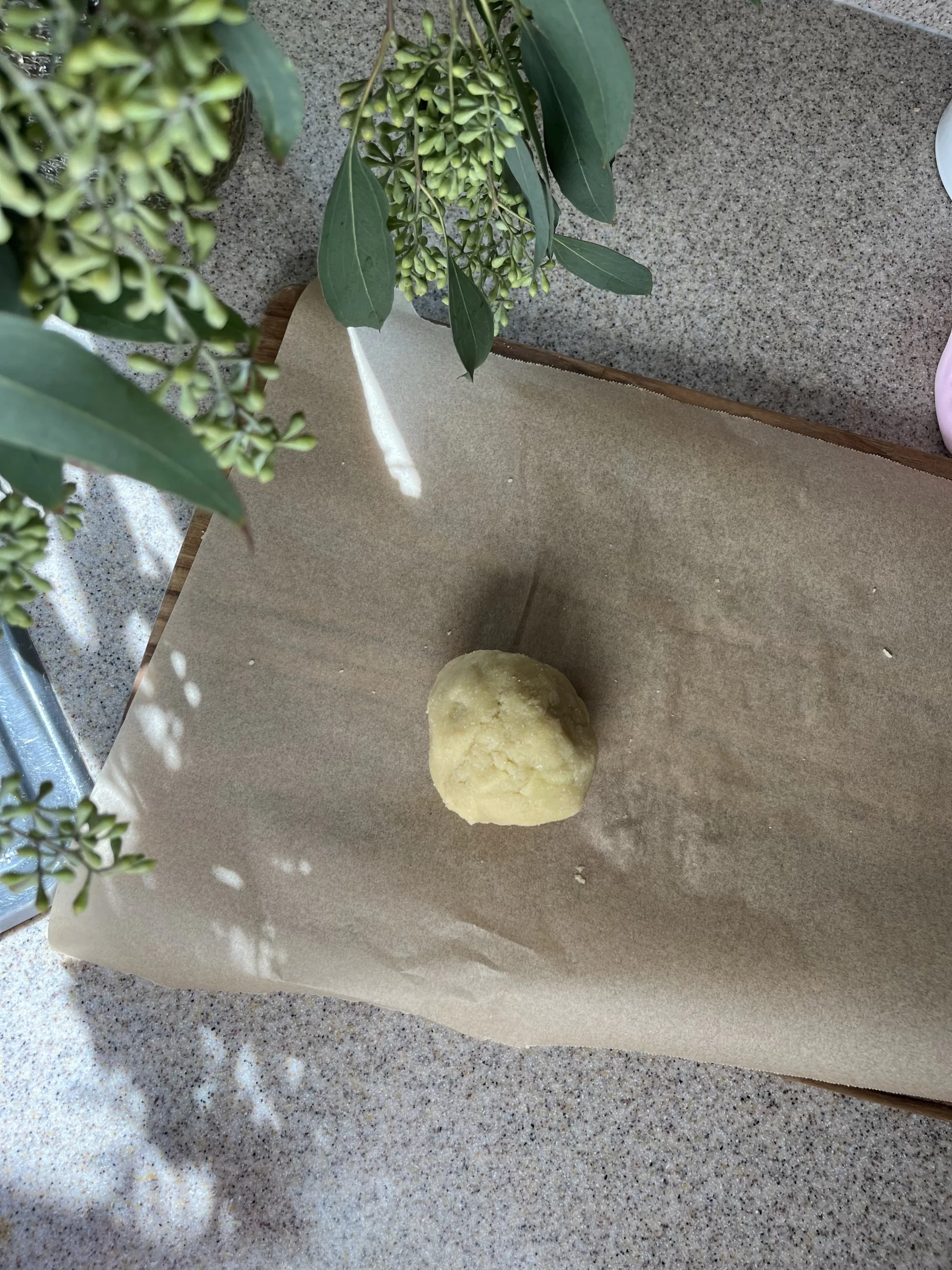 A ball of dough on top of a piece of parchment paper.