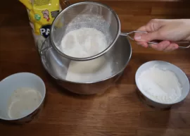 Gluten-free flour being sifted into a bowl.