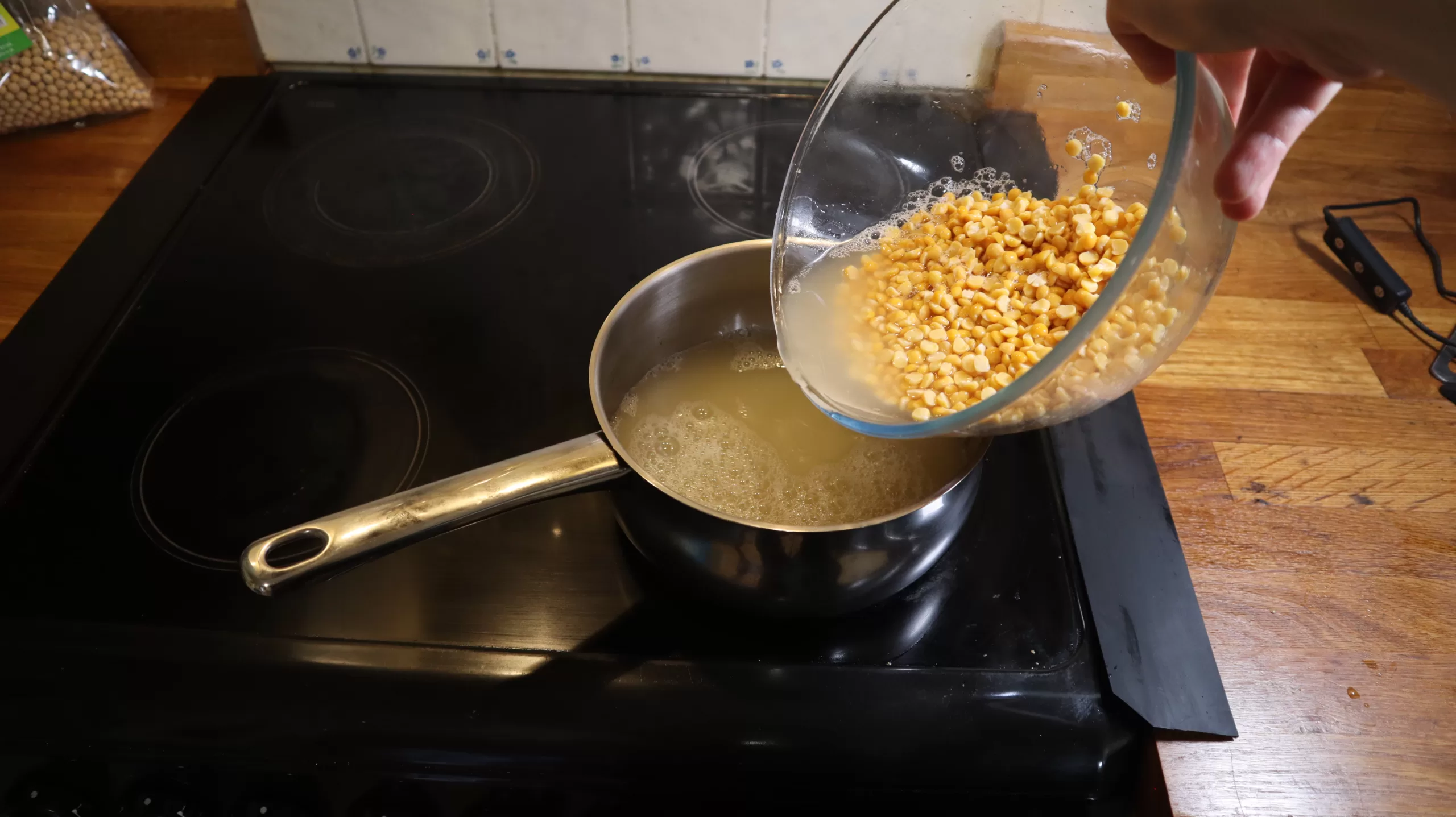 Peas adding to a saucepan.
