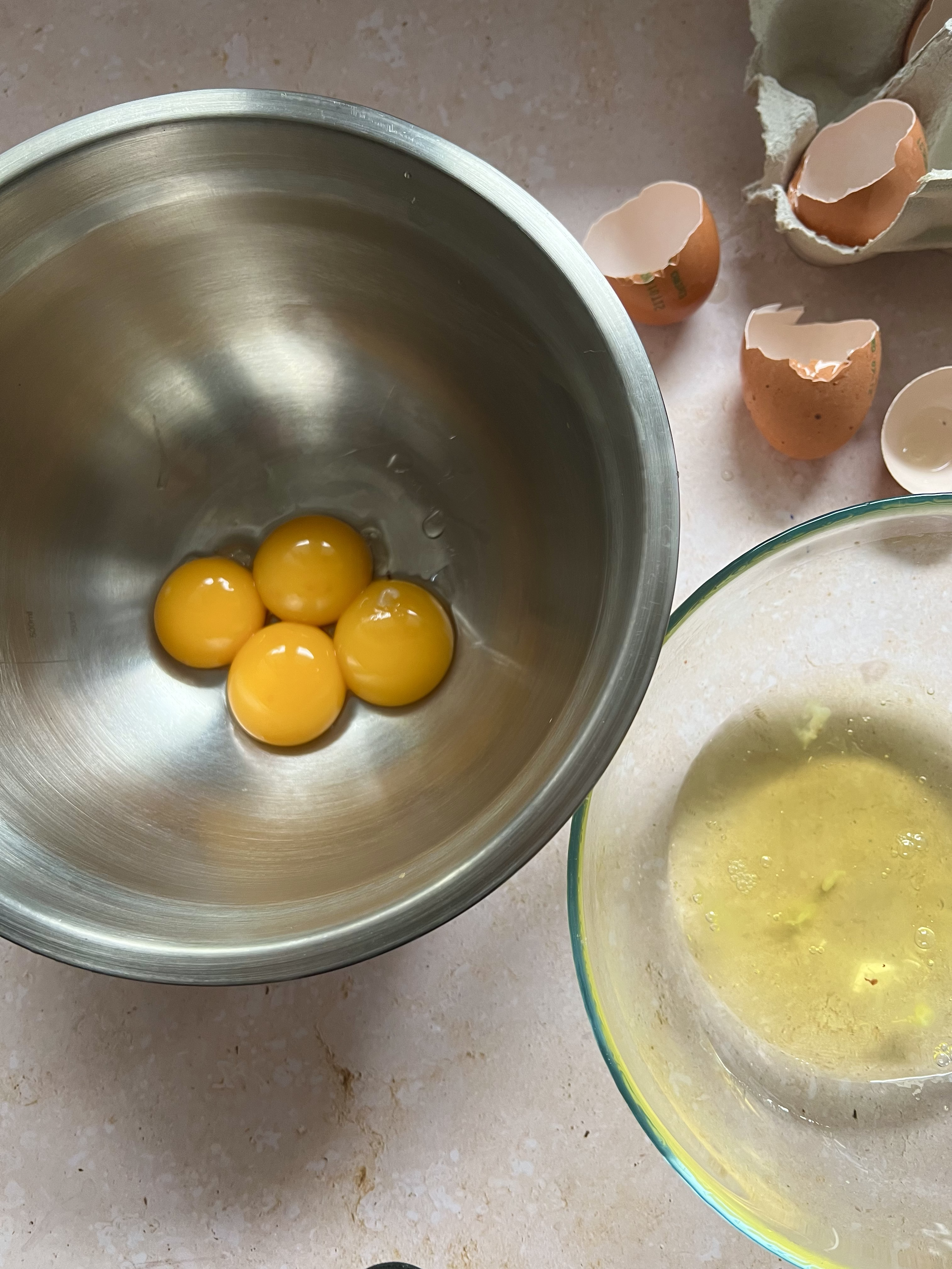 Overhead shot of egg yolks and egg whites in two different bowls. 