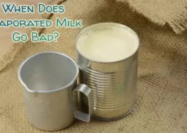 A burlap napkin displaying an empty metal jug and an open can of evaporated milk. The text reads, "When Does Evaporated Milk Go Bad?"