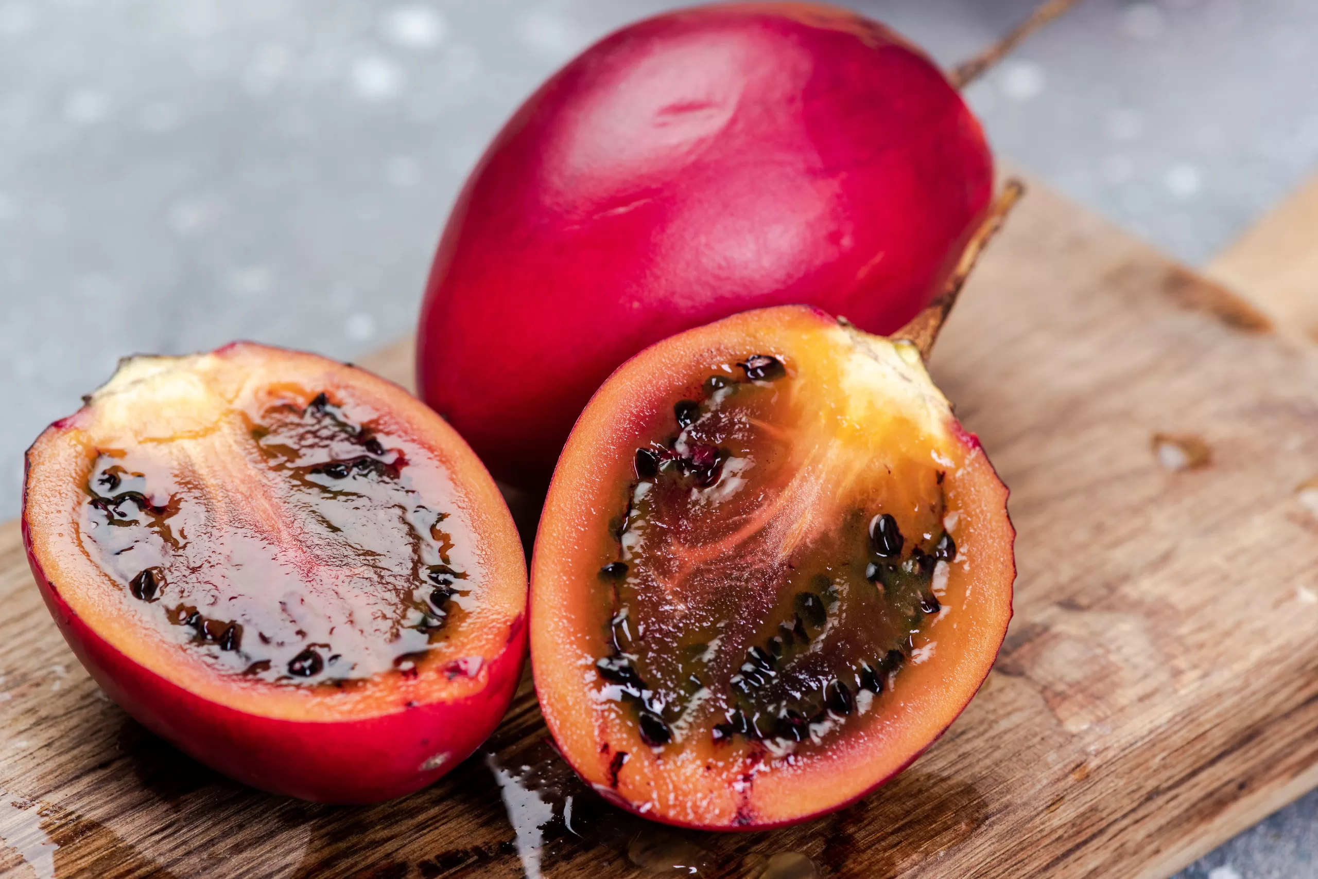 A few fresh tamarillos resting on a chopping board. 