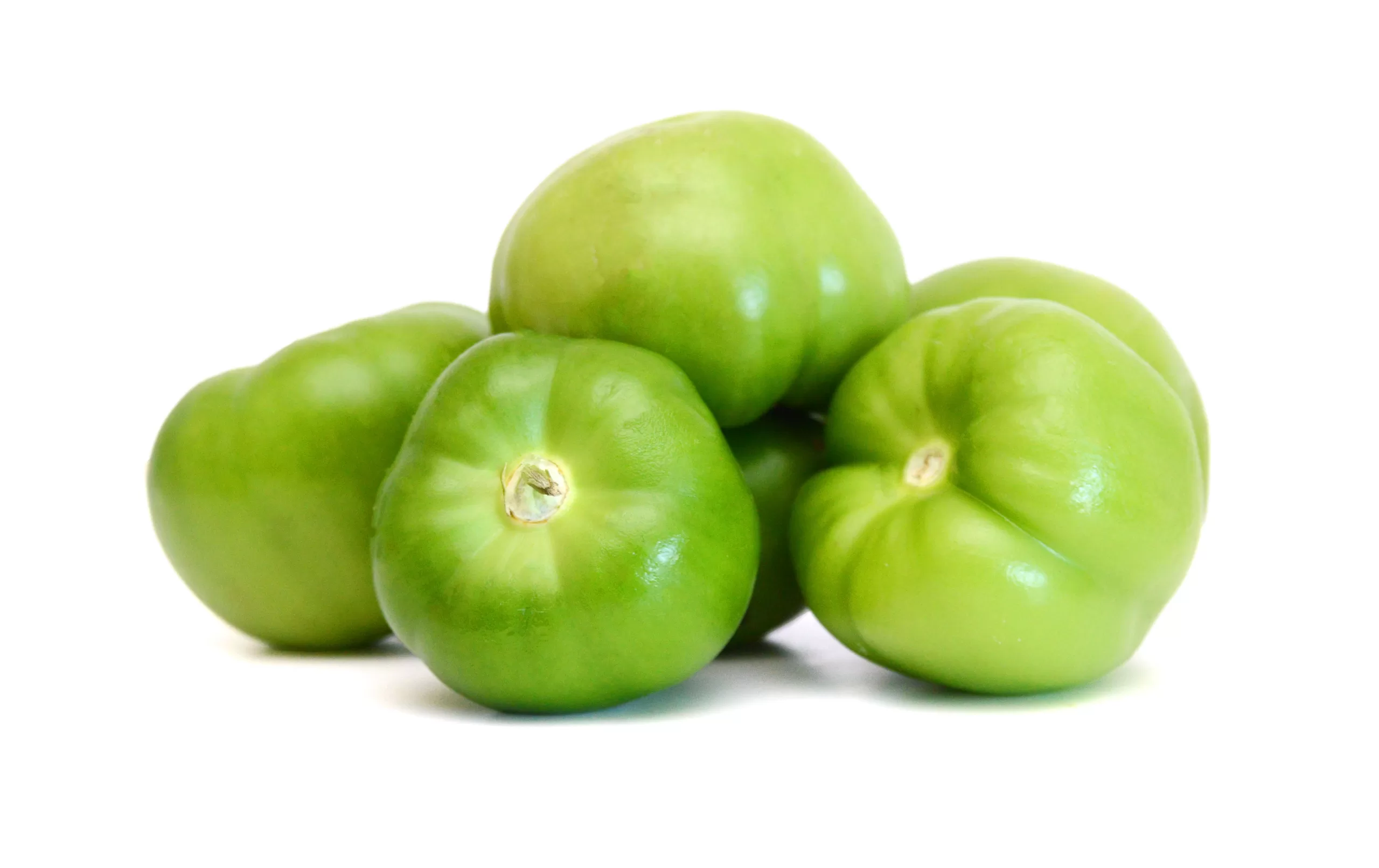 A mound of freshly harvested tomatillos on a white background.