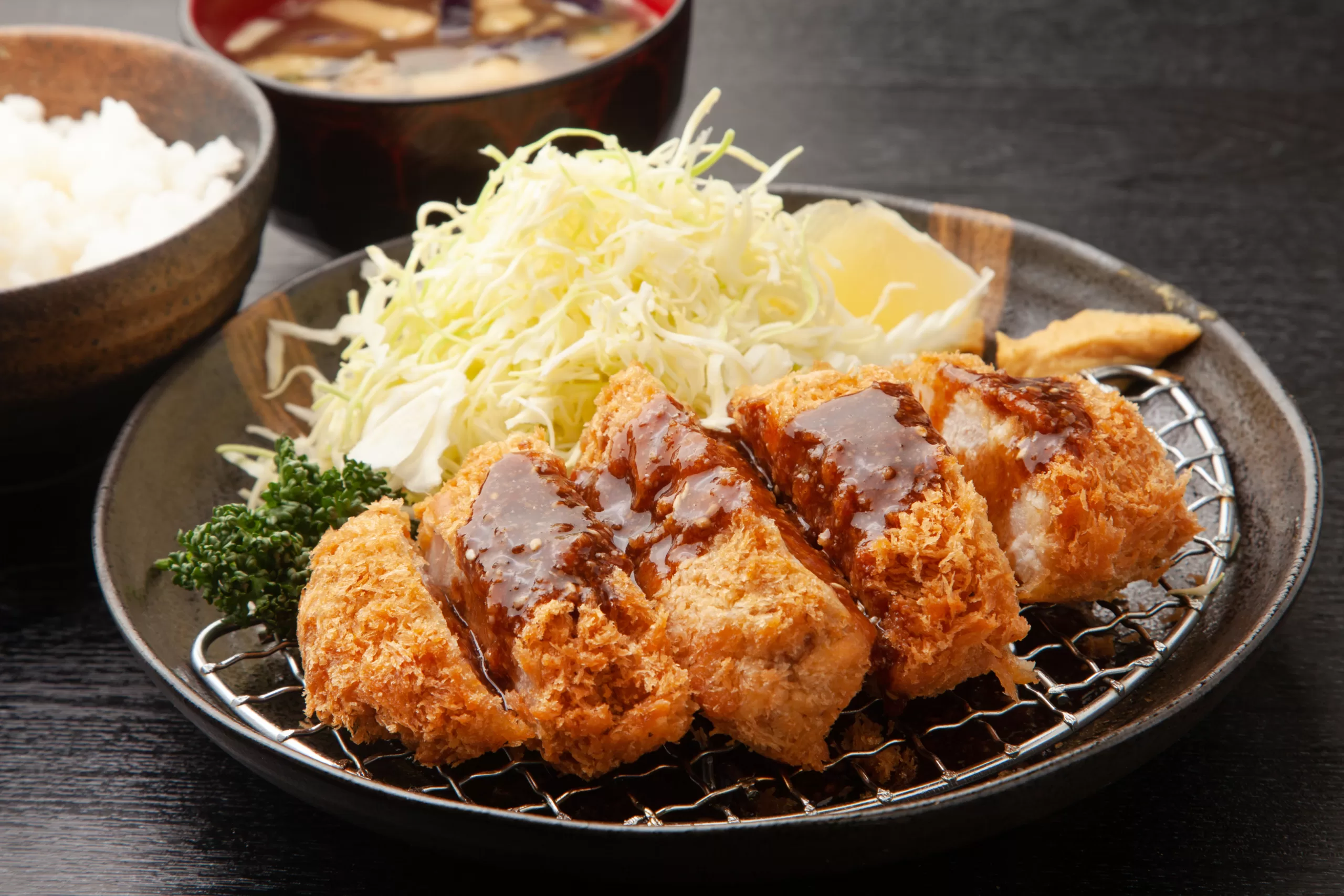 A portion of tonkatsu with chopped white cabbage. 