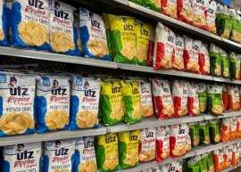 Bags of Utz potato chips on store shelves in various flavors.