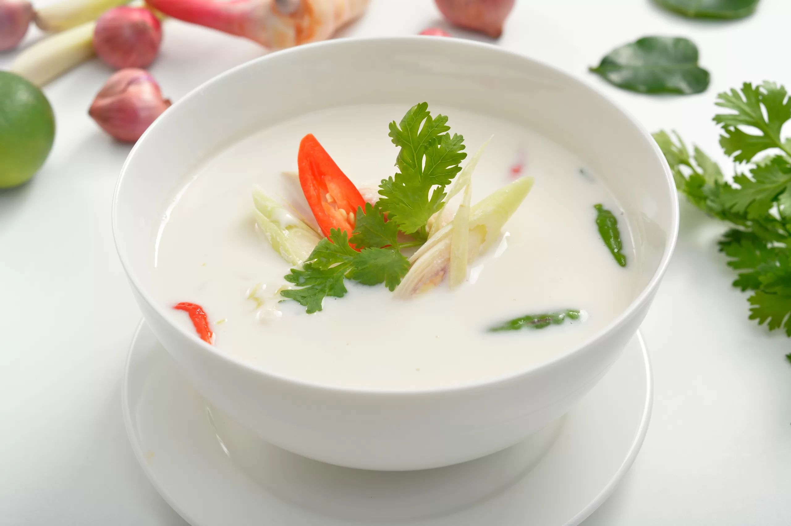 A serving of tasty tom kha gai, accompanied by some of its components.