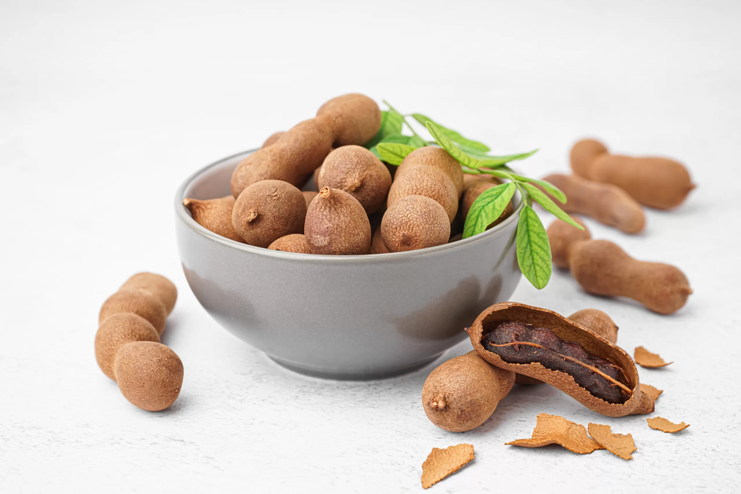 A bowl overflowing with tamarindos. 