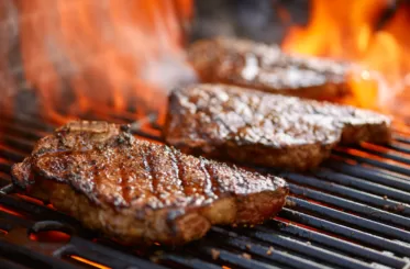 Steaks grilled on a flaming grill