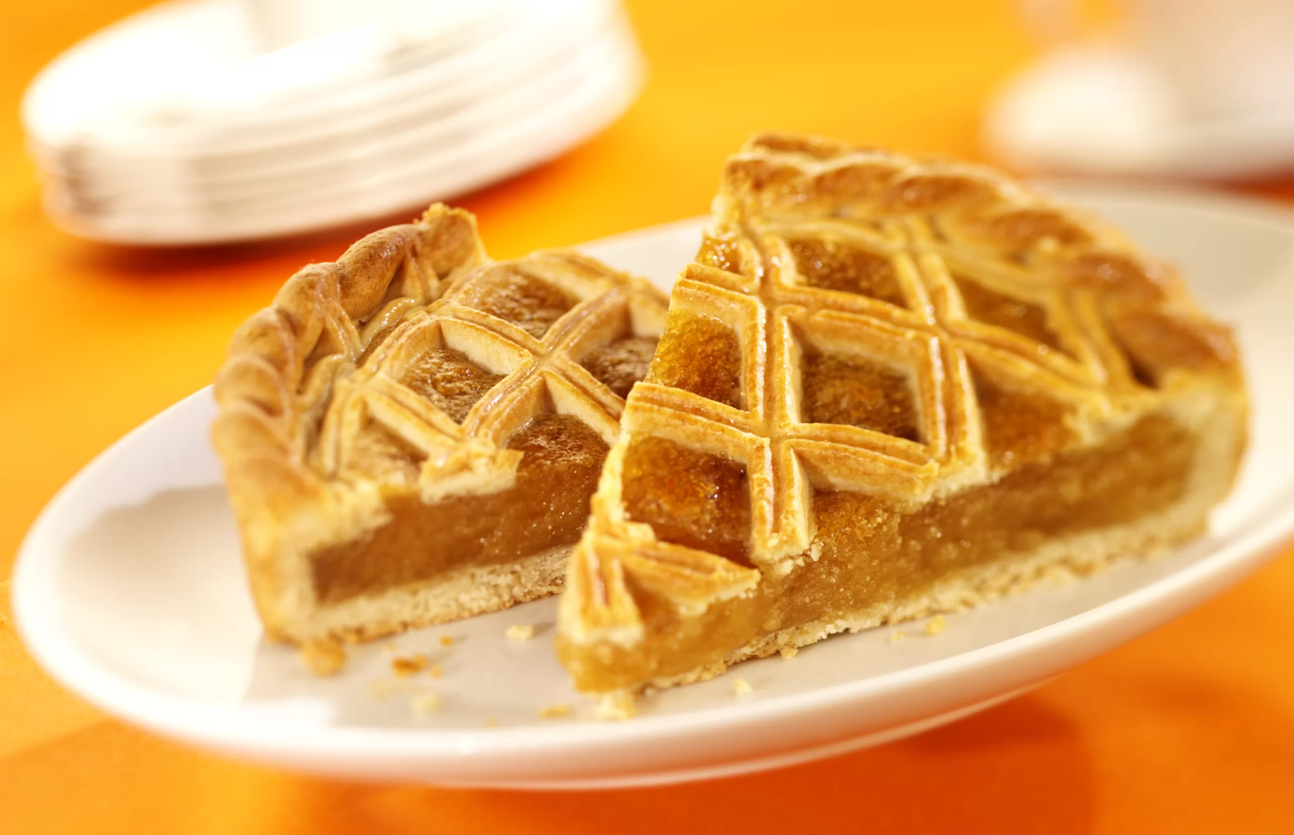 A pair of slices of homemade treacle tart on a single plate. 