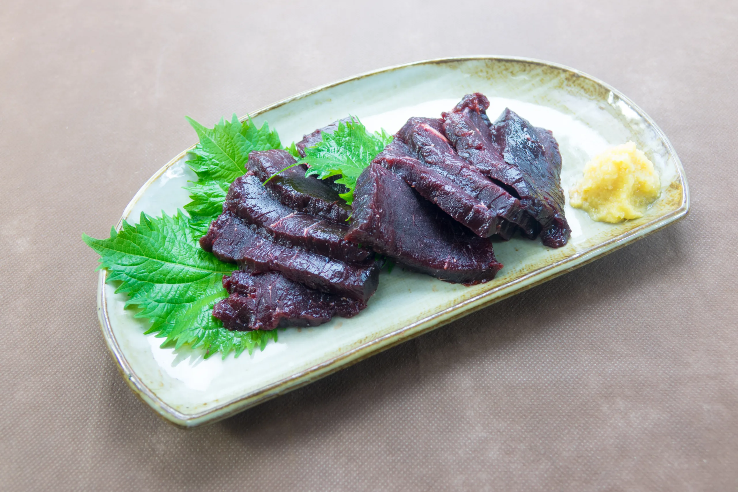 A few whale meat slices on a tray.