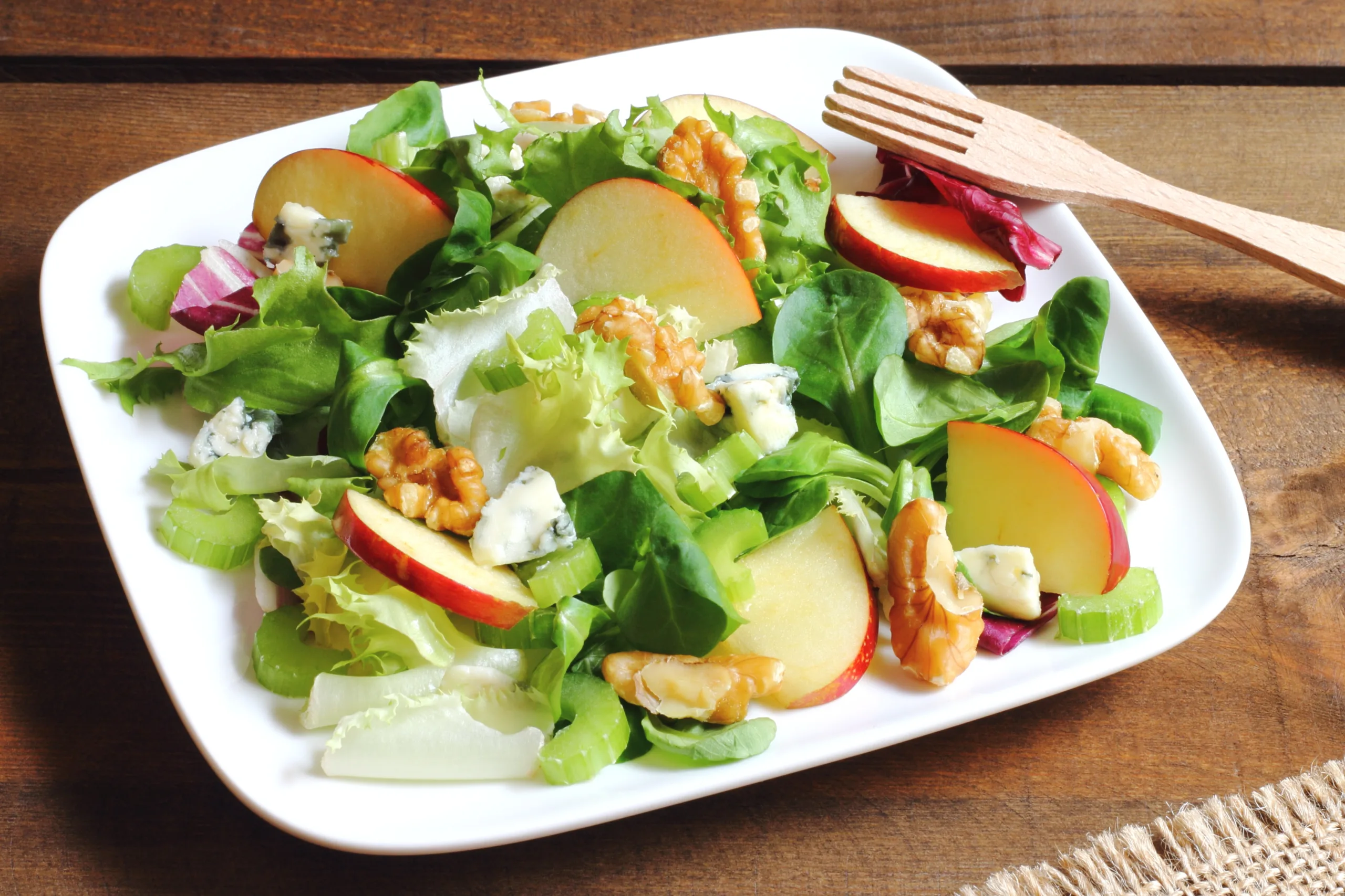 A portion of Waldorf salad on a wooden table.