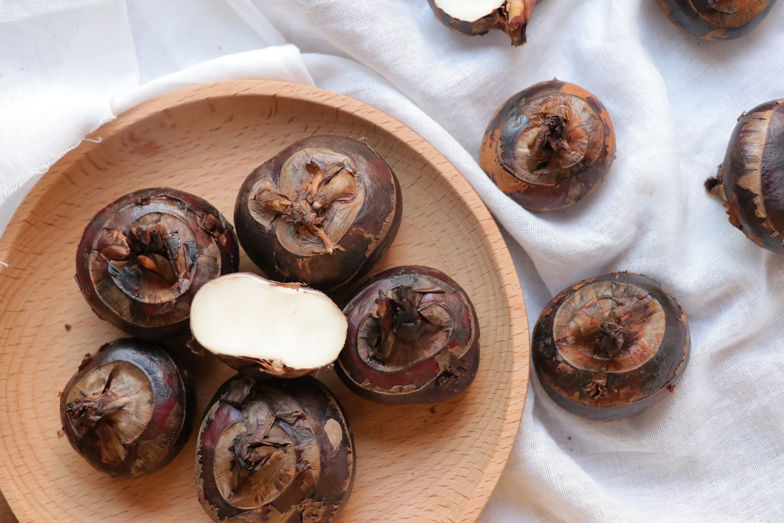 Overhead view of a wooden plate overflowing with water chestnuts.