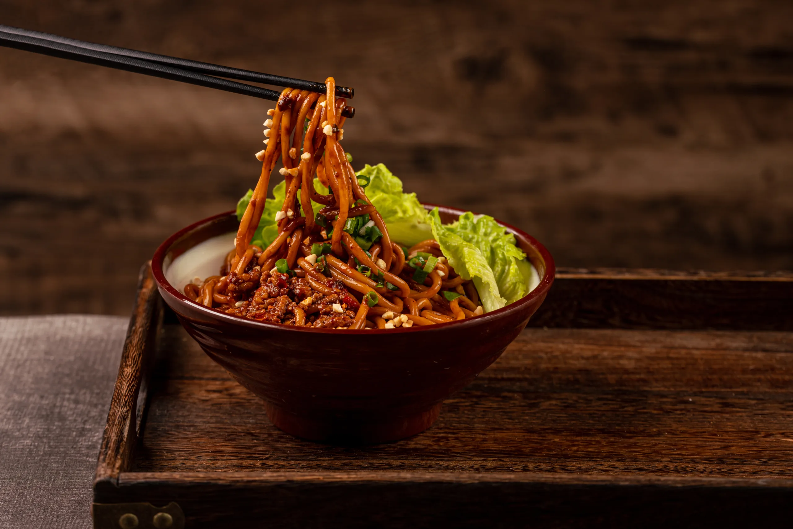 Traditional Wuhan noodles on a wooden tray.