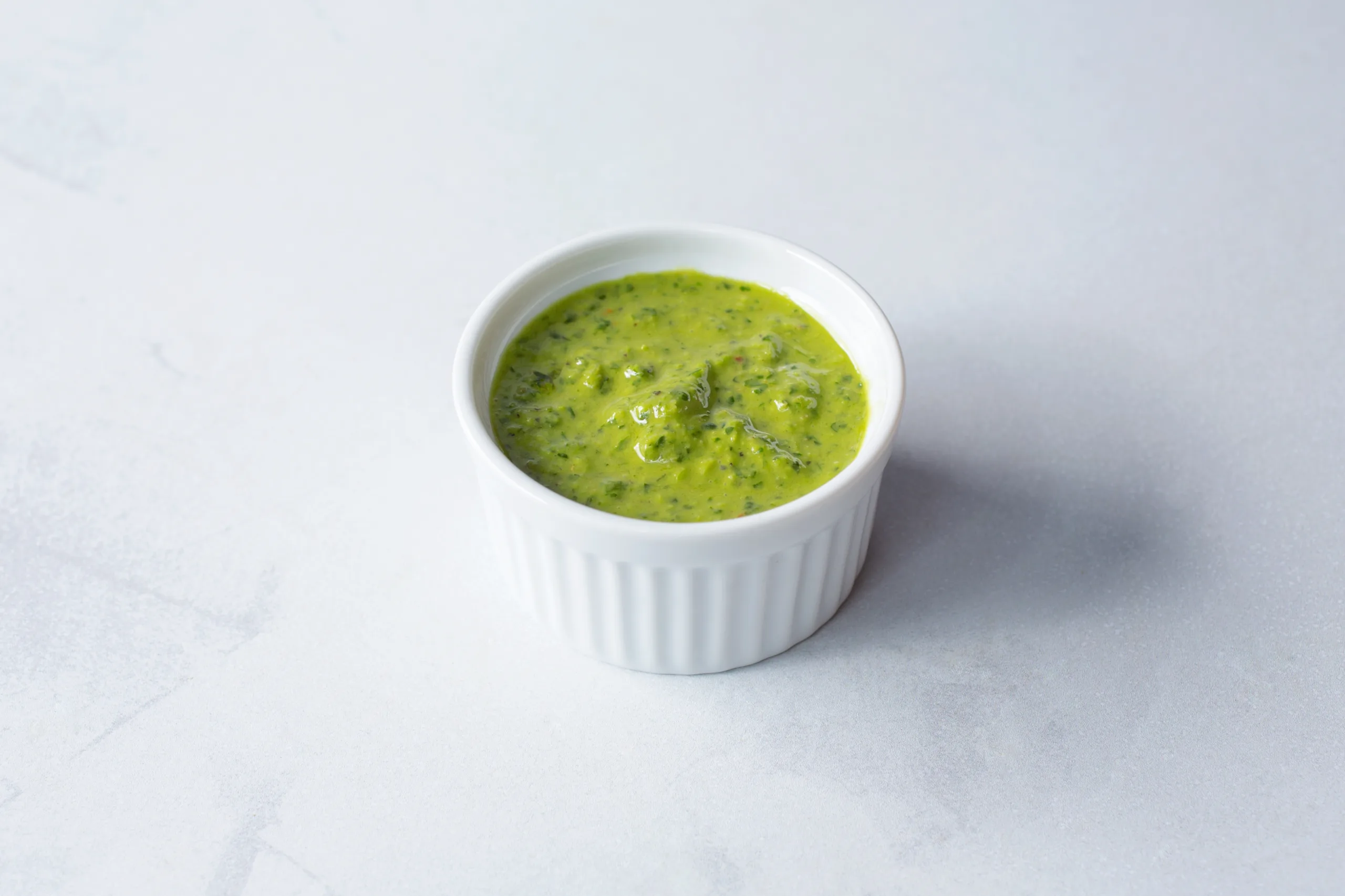 An isolated bowl of zhoug yogurt dip.