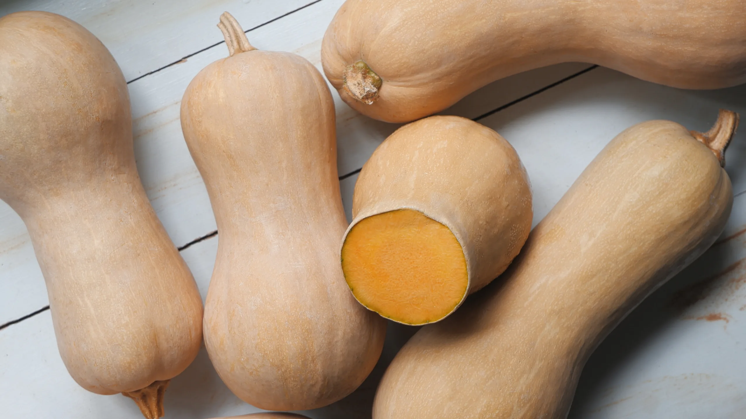Top view of a wooden table holdin some fresh winter squashes.