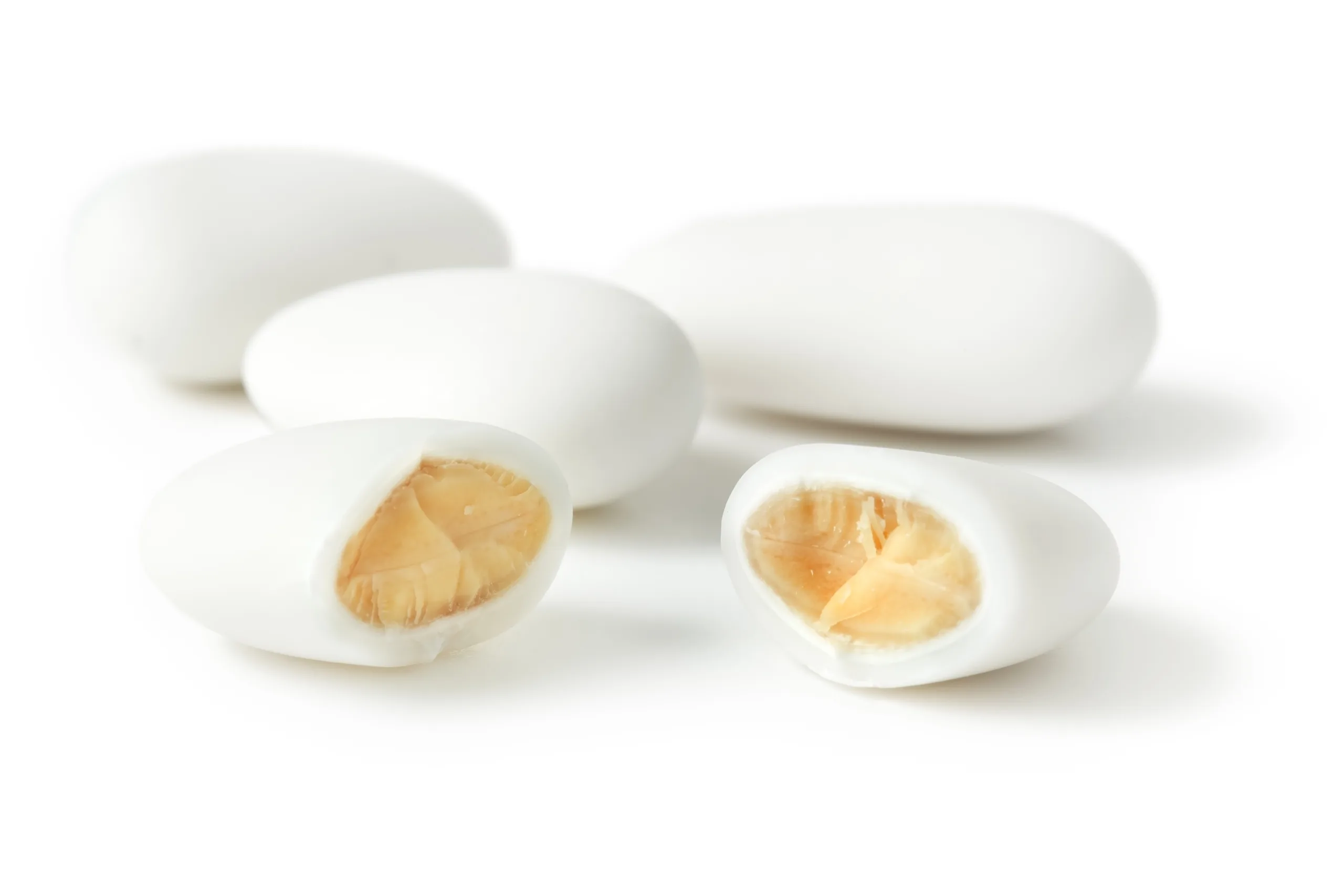 A few white almond against a plain background.
