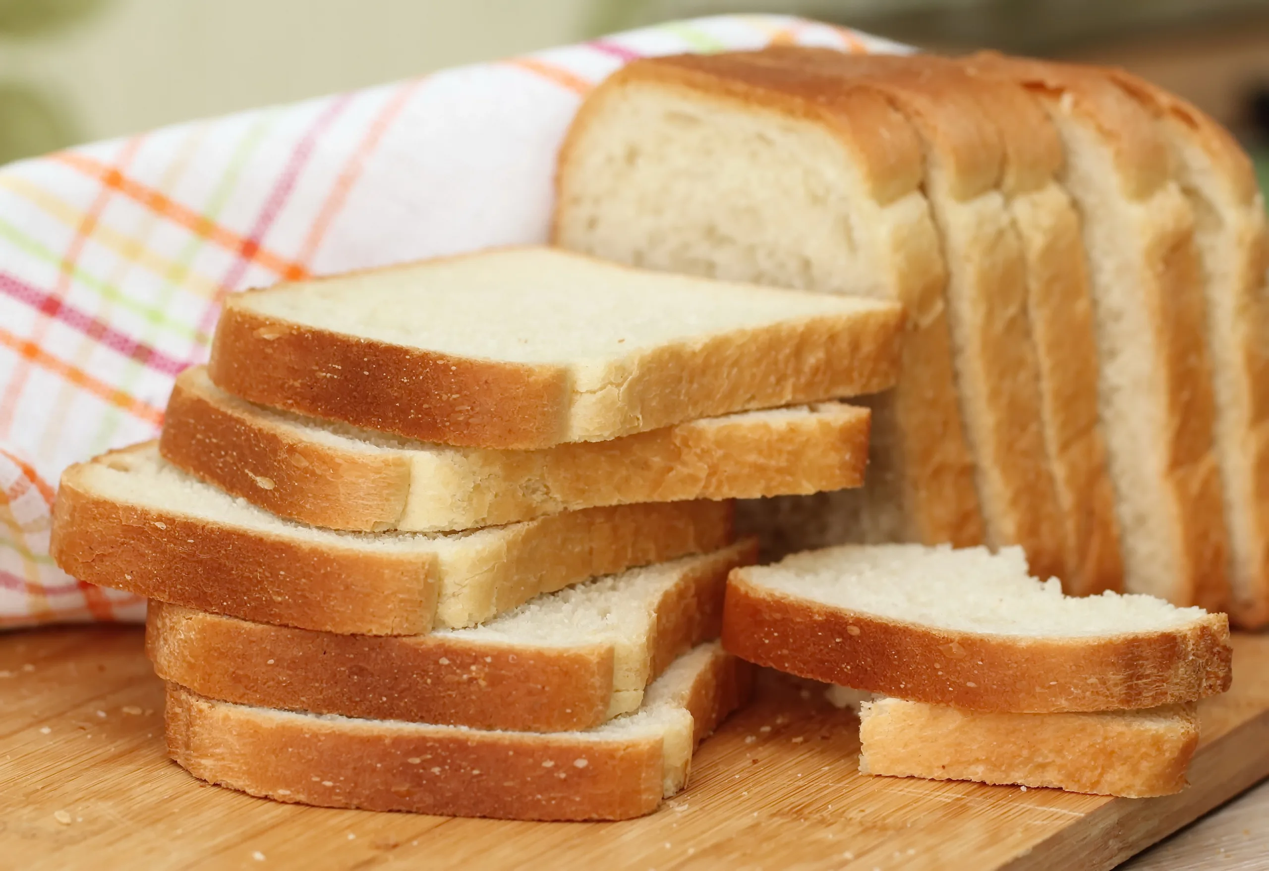 Macro shot of white bread slices on a chopping board.