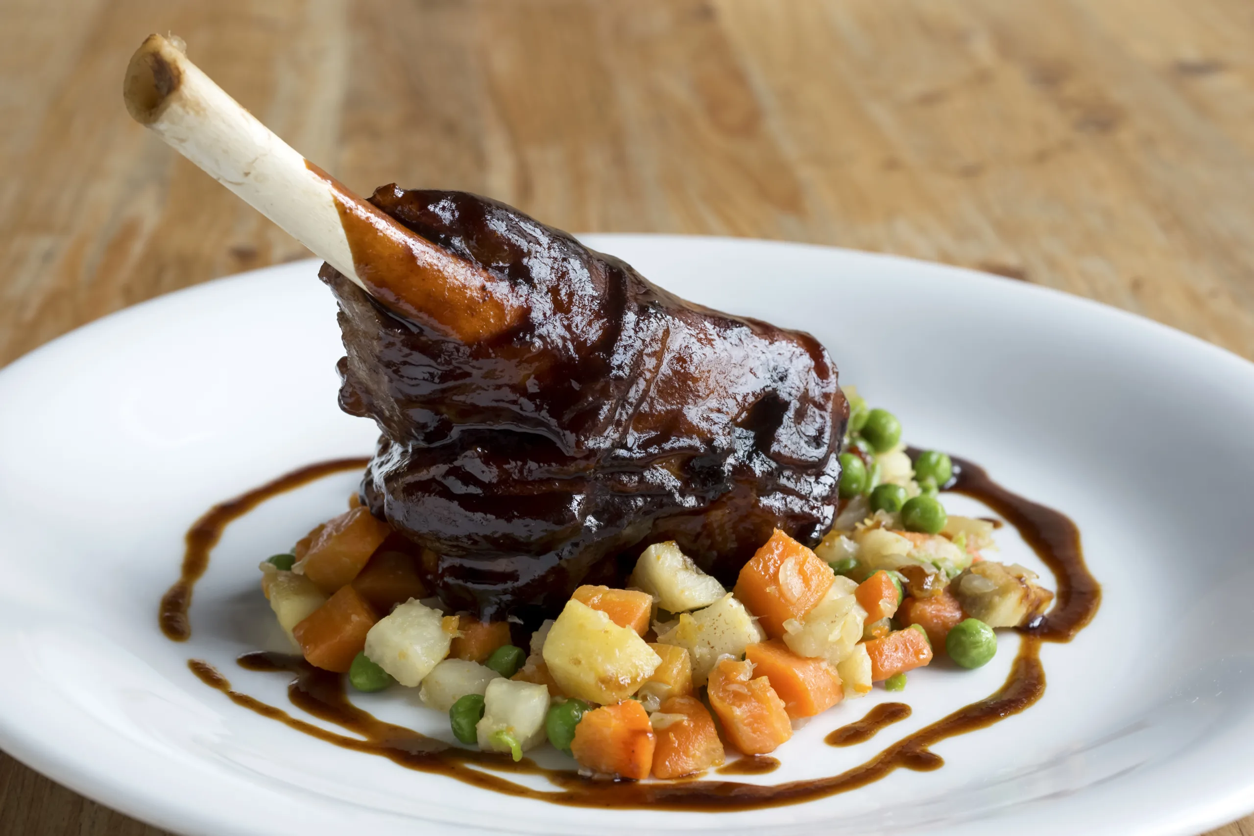 A portion of zinfandel-braised short ribs on a bed of chopped vegetables.