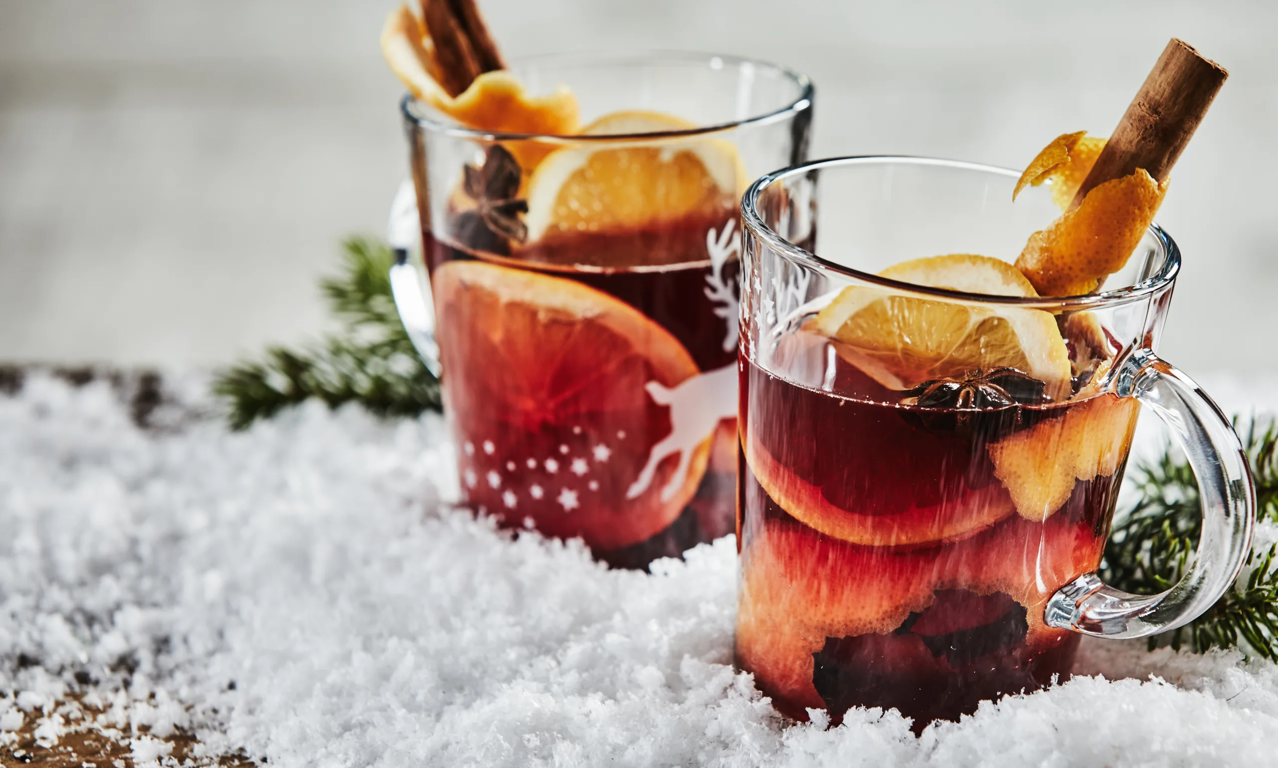 A pair of cups of wassail resting on chopped ice.