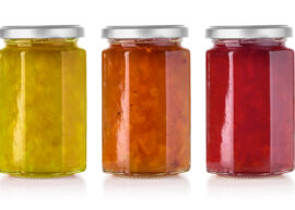 A white background featuring three jars of jam.