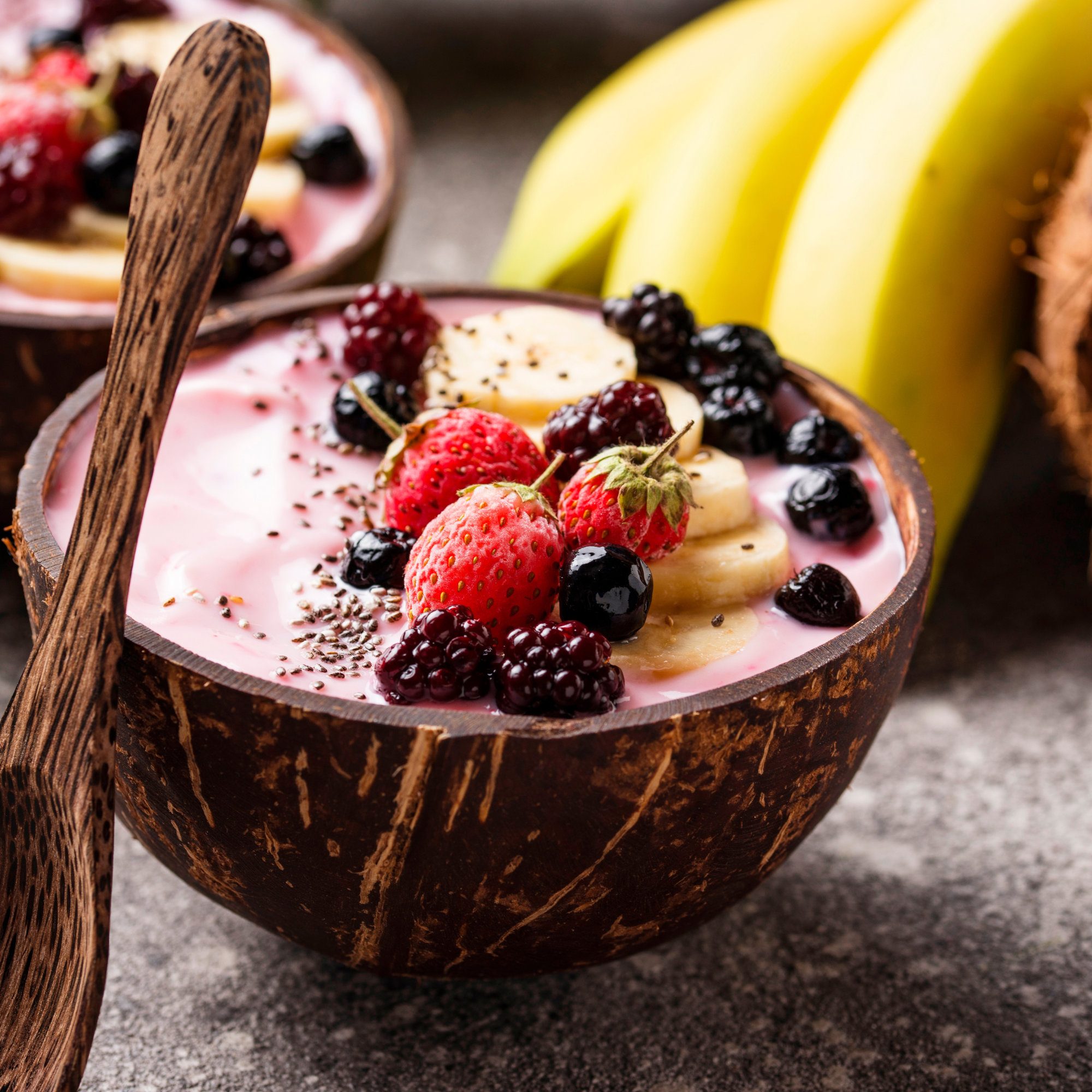 A coconut bowl filled with smoothie and berries.