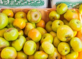 A basket filled with fresh green apples.