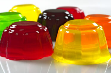 Assorted colorful jelly molds in various colors on a white surface.