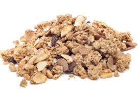 Pile of granola with dried fruits and nuts on white background