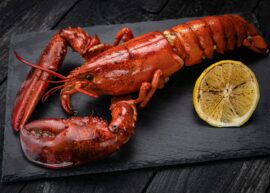 Grilled lobster on slate with lemon wedge