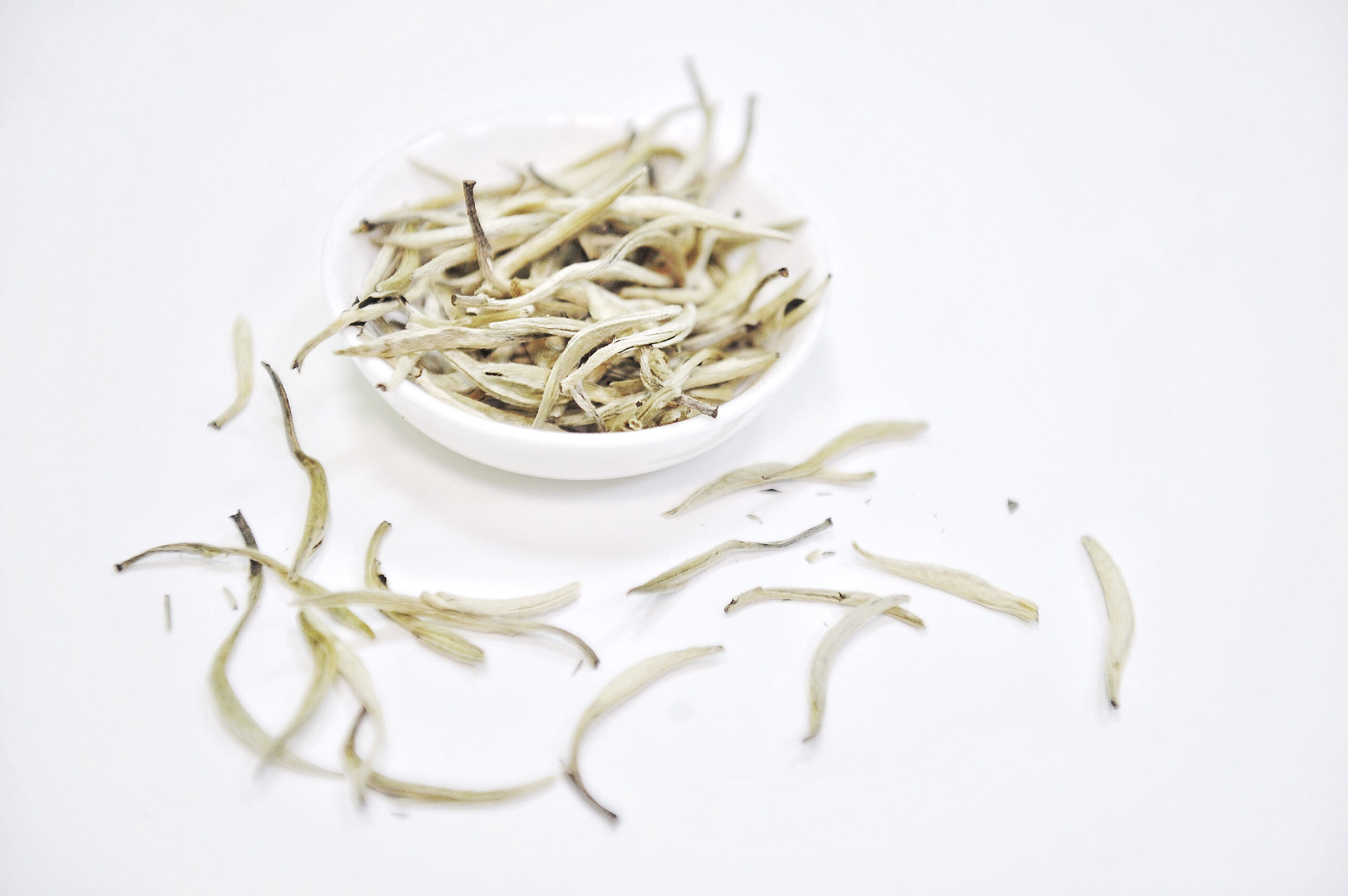 A bowl overflowing with white tea strands.
