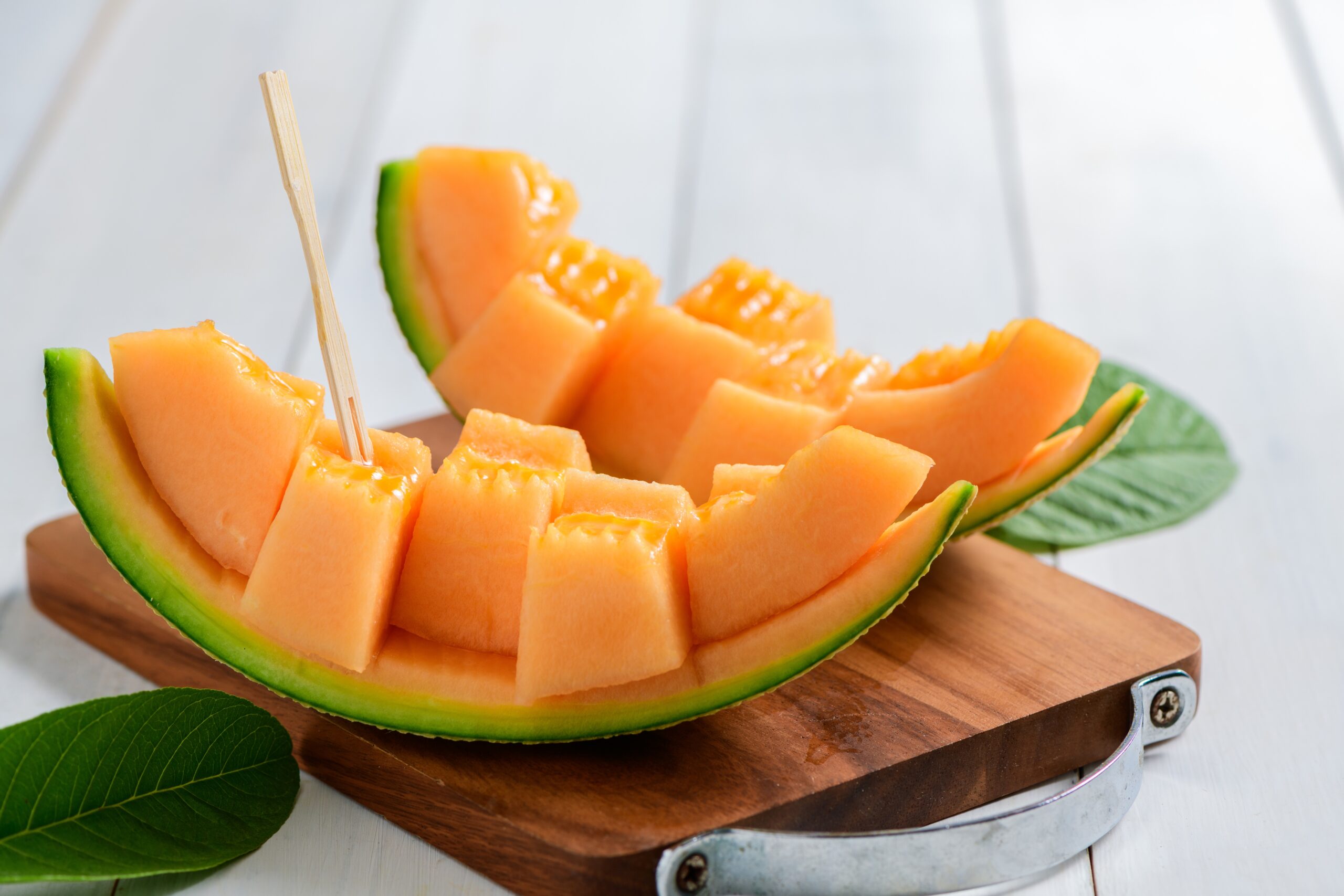 Slice,Of,Orange,Melon,Or,Cantaloupe,Melon,On Cantaloupe cubes resting on a chopping board.