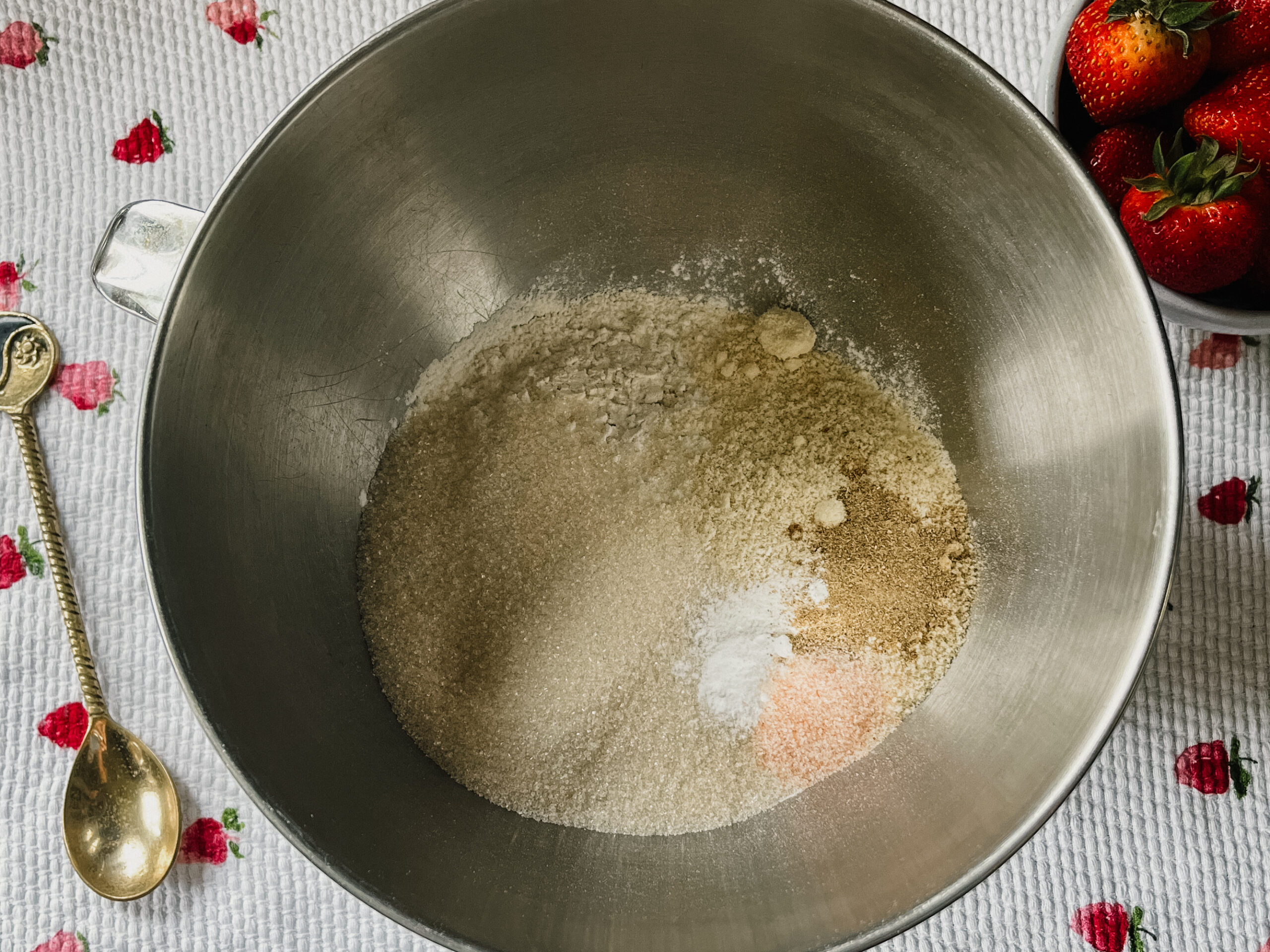 Ingredients for a strawberry shortcake inside a silver bowl, about to be mixed.