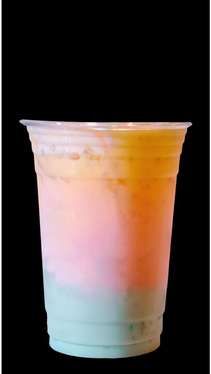 Rainbow,Milkshake. A single plastic cup of rainbow milkshake on a black background.