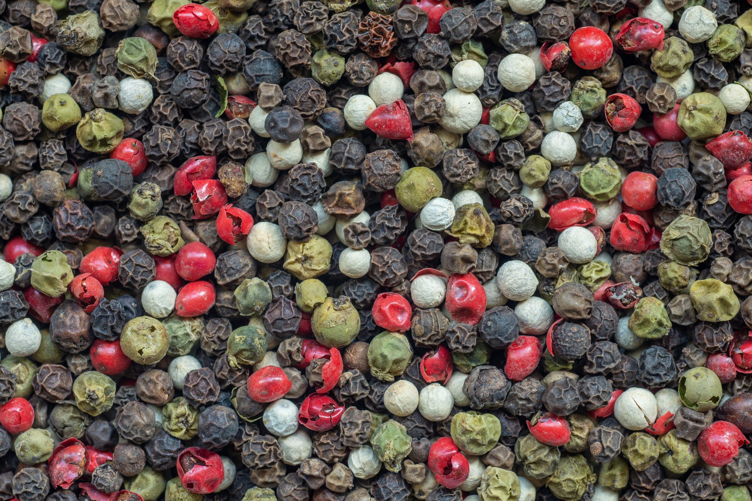 Four peppercorn types, which compose rainbow peppercorn mix. 