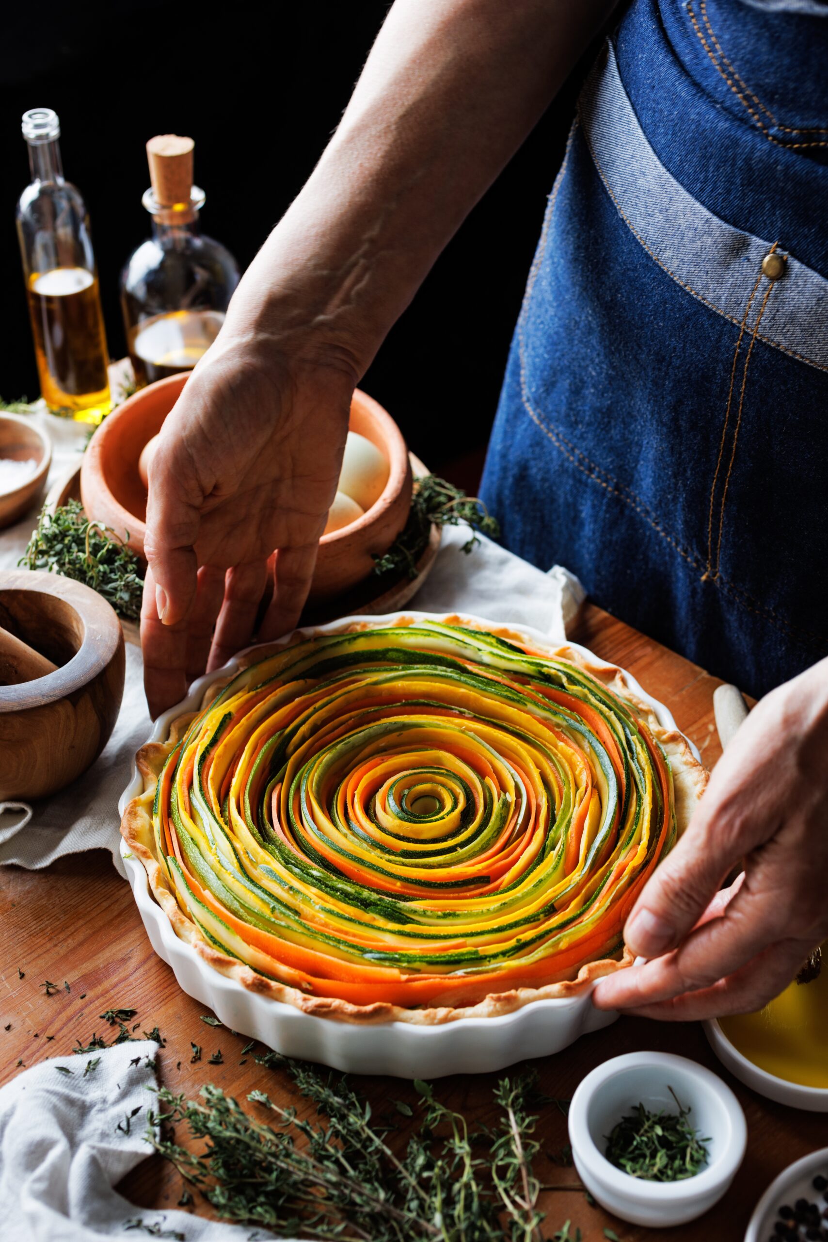 A man preparing a rainbow quiche. 