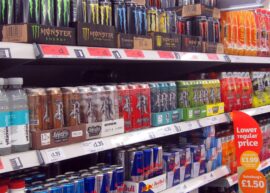 Various energy drink brands displayed on store shelves.