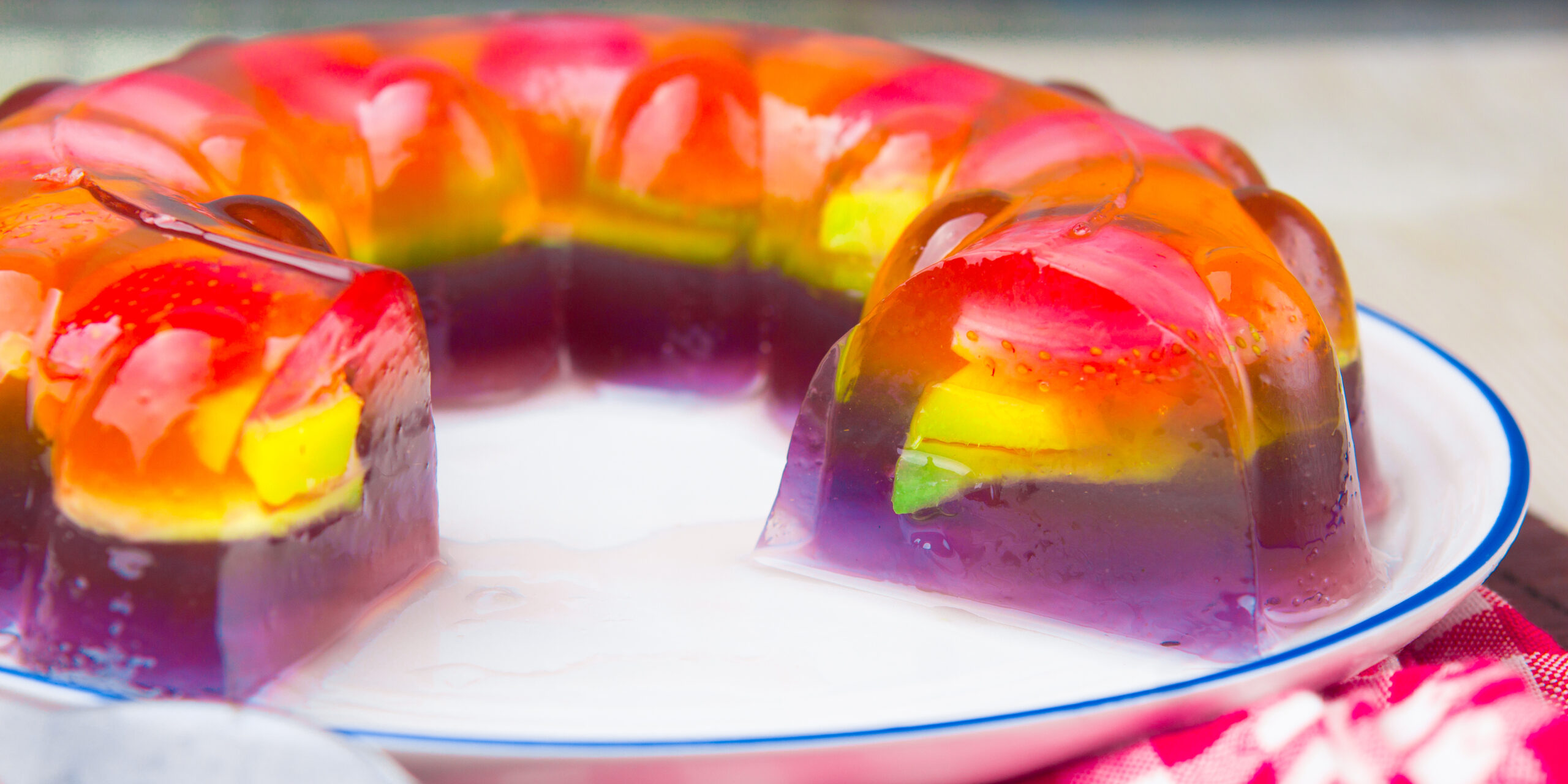 A partially cut layered rainbow jello.