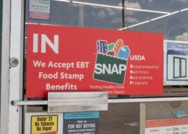 Sign in front of a store says "IN We accept EBT Food Stamp Benefits"